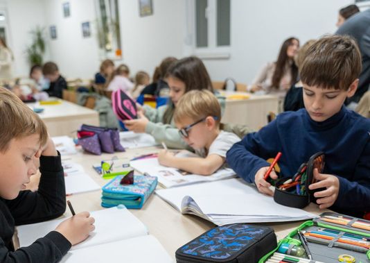Učenici crtaju i pišu za klupama u učionici Clever škole