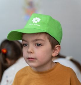 Mlađi učenik u zelenom Clever School kačketu