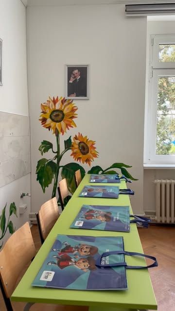 Učionica sa muralom suncokreta i poklon-kesama na zelenim klupama